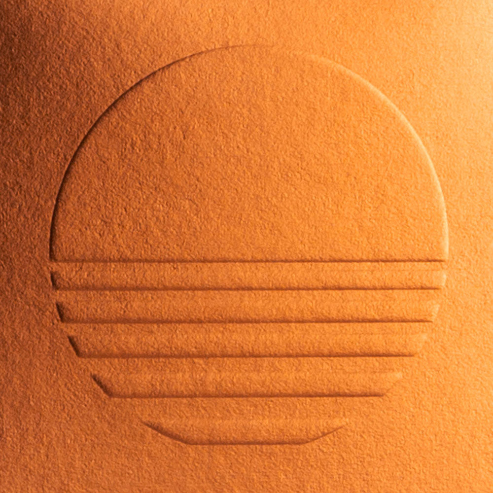 Close up of the Mojave Myst logo icon embossed on a copper-colored texture