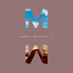The Mojave Myst MM icon with sky and red rocks coloring in its letter shapes on a mauve background.