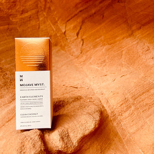
                  
                    A luxury box of Mojave Myst Molecular Spray Deodorant resting on a small ledge of a red rock.
                  
                